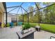 Screened patio featuring outdoor seating, green lawn, and private backyard at 12592 Ryegrass Loop, Parrish, FL 34219