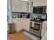 Well-lit kitchen featuring white cabinets, modern stainless steel appliances, and stylish backsplash at 12809 7Th Ne Ave, Bradenton, FL 34212