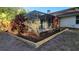 Enclosed patio area with tropical landscaping and a freshly mulched garden bed, for enjoying the outdoors in comfort at 12809 7Th Ne Ave, Bradenton, FL 34212