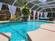 Inviting screened pool area with a cascading waterfall feature, tropical plants, and lounge seating at 12809 7Th Ne Ave, Bradenton, FL 34212