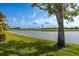 The serene lake glistens under a bright blue sky, bordering a well-manicured golf course at 1322 Millbrook Cir, Bradenton, FL 34212