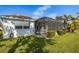 Exterior showing a screened-in patio, light-colored house and tropical palm trees on a sunny day at 1322 Millbrook Cir, Bradenton, FL 34212