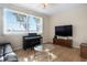 Sunlit living room features hardwood floors, a large window offering scenic views, and comfortable seating at 1322 Millbrook Cir, Bradenton, FL 34212