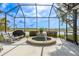 Relaxing outdoor area featuring a screened-in patio with a hot tub and scenic lake views at 1322 Millbrook Cir, Bradenton, FL 34212