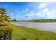 Scenic view of the community pond with palm trees and lush landscaping around the area at 1322 Millbrook Cir, Bradenton, FL 34212