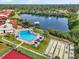 Aerial view showcasing a pool, lake, shuffleboard, and tennis courts within a community at 1421 57Th W St # 1421, Bradenton, FL 34209