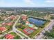 Aerial view showing a community with a lake, tennis courts, and clubhouse at 1421 57Th W St # 1421, Bradenton, FL 34209