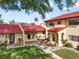 Beautiful condo with a red tiled roof, lush green lawn, and inviting walkways at 1421 57Th W St # 1421, Bradenton, FL 34209