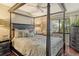 Cozy bedroom with a four poster bed, ceiling fan and natural light from a window overlooking the verdant yard at 1720 Glenhouse Dr # Gl430, Sarasota, FL 34231