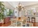 Charming dining area with hardwood floors, elegant chandelier, and views of lush greenery at 1720 Glenhouse Dr # Gl430, Sarasota, FL 34231