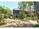 Back exterior of a building surrounded by mature green tropical landscape and a private porch at 1720 Glenhouse Dr # Gl430, Sarasota, FL 34231