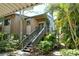 Exterior view of the condo with lush tropical plants and staircase to entry at 1720 Glenhouse Dr # Gl430, Sarasota, FL 34231