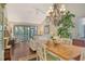 A bright living room with hardwood floors, a chandelier, and access to the screened-in porch at 1720 Glenhouse Dr # Gl430, Sarasota, FL 34231