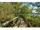 Scenic wooden boardwalk path winds through lush greenery, leading to tranquil waterfront views at 1720 Glenhouse Dr # Gl430, Sarasota, FL 34231