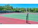 Community tennis court on a sunny day surrounded by trees and lush landscaping at 1720 Glenhouse Dr # Gl430, Sarasota, FL 34231