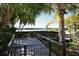 View from a wooden deck overlooking a body of water surrounded by tropical trees and landscaping at 1720 Glenhouse Dr # Gl430, Sarasota, FL 34231