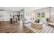 Bright, open-concept living room featuring wood floors, modern decor, and a large window overlooking the backyard at 1738 Cobb Trl, Parrish, FL 34219