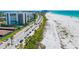 Coastal view of beachfront condos along soft white sand and boulevard lined with palms at 1750 Benjamin Franklin Dr # 6B, Sarasota, FL 34236