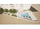 Aerial view of a building's pool area with palm trees, lounge chairs, and umbrellas at 1750 Benjamin Franklin Dr # 6B, Sarasota, FL 34236