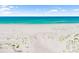 Aerial view of a serene, sandy beach with sparse vegetation and turquoise water at 1750 Benjamin Franklin Dr # 6B, Sarasota, FL 34236
