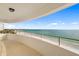 Expansive balcony overlooking the beach with white railings and neutral stone flooring at 1750 Benjamin Franklin Dr # 6B, Sarasota, FL 34236