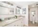 Bright bathroom features double sinks, granite countertops, and decoratively framed mirrors at 1750 Benjamin Franklin Dr # 6B, Sarasota, FL 34236