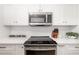 Contemporary kitchen with stainless steel appliances, white cabinets, and sleek countertops at 1750 Benjamin Franklin Dr # 6B, Sarasota, FL 34236
