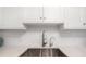 Modern kitchen featuring a stainless steel sink, bright white cabinets, and beautiful countertops at 1750 Benjamin Franklin Dr # 6B, Sarasota, FL 34236