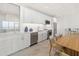 A modern kitchen and dining area featuring modern appliances, white cabinetry, and ample seating at 1750 Benjamin Franklin Dr # 6B, Sarasota, FL 34236