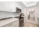 Well-maintained kitchen features white cabinets, quartz countertops, and stainless steel appliances at 1750 Benjamin Franklin Dr # 6B, Sarasota, FL 34236