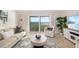 Relaxing living room with modern decor, a comfortable sofa, and scenic ocean views from a sliding glass door at 1750 Benjamin Franklin Dr # 6B, Sarasota, FL 34236