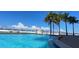 Inviting pool with clear blue water, palm trees, and ocean views at 1750 Benjamin Franklin Dr # 6B, Sarasota, FL 34236