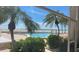 Stunning view of the pool and beach through lush tropical foliage at 1750 Benjamin Franklin Dr # 6B, Sarasota, FL 34236