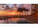 Beautiful sunset reflecting on the pool near palm trees and beach chairs at 1750 Benjamin Franklin Dr # 6B, Sarasota, FL 34236
