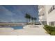 Inviting pool area with palm trees, lounge chairs, umbrellas, and ocean views at 1750 Benjamin Franklin Dr # 6B, Sarasota, FL 34236