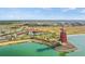 Aerial view of community lake, red lighthouse, pool, and clubhouse with lush landscaping at 17549 Timberline Pkwy, Punta Gorda, FL 33982