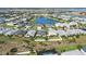 Aerial view of community featuring lush landscaping and a central pond at 17549 Timberline Pkwy, Punta Gorda, FL 33982