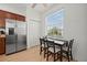 Bright kitchen nook featuring stainless steel refrigerator and a cozy dining table with seating for four at 17549 Timberline Pkwy, Punta Gorda, FL 33982