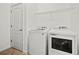 Bright laundry room featuring appliances, tile floor and storage shelf at 17549 Timberline Pkwy, Punta Gorda, FL 33982