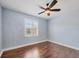 Bedroom features hardwood floors, blue walls, bright windows with plantation shutters, and a ceiling fan at 1815 Grove St, Sarasota, FL 34239