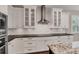 Modern kitchen features white cabinets, subway tile backsplash, stainless steel range hood and black countertops at 1815 Grove St, Sarasota, FL 34239