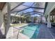 A beautiful backyard pool with a screened enclosure, lush landscaping, and an outdoor entertainment area at 1815 Grove St, Sarasota, FL 34239