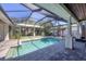 A beautiful backyard pool with a screened enclosure, lush landscaping, and an outdoor entertainment area at 1815 Grove St, Sarasota, FL 34239