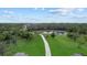 Aerial view showcases the meticulously maintained grounds and a serene pond with a dock at 20307 74Th E Ave, Bradenton, FL 34202