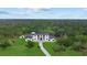 Aerial view of a modern home surrounded by lush greenery and a long driveway at 20307 74Th E Ave, Bradenton, FL 34202