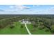 Aerial view of a modern home with a long driveway surrounded by lush greenery at 20307 74Th E Ave, Bradenton, FL 34202