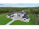 An aerial view displays the modern home, landscaping, and multiple buildings on the property at 20307 74Th E Ave, Bradenton, FL 34202