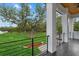 View from the balcony with black metal railings overlooking the green grounds and outbuildings at 20307 74Th E Ave, Bradenton, FL 34202