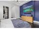 Stylish bedroom with dark wood floors, a blue accent wall, and a large television at 20307 74Th E Ave, Bradenton, FL 34202