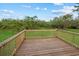 Wooden deck overlooks a lush landscape and bright blue sky with light clouds at 20307 74Th E Ave, Bradenton, FL 34202